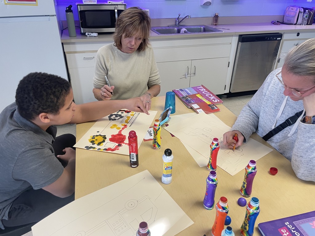 A student describing what he wants staff to draw for his journal time.