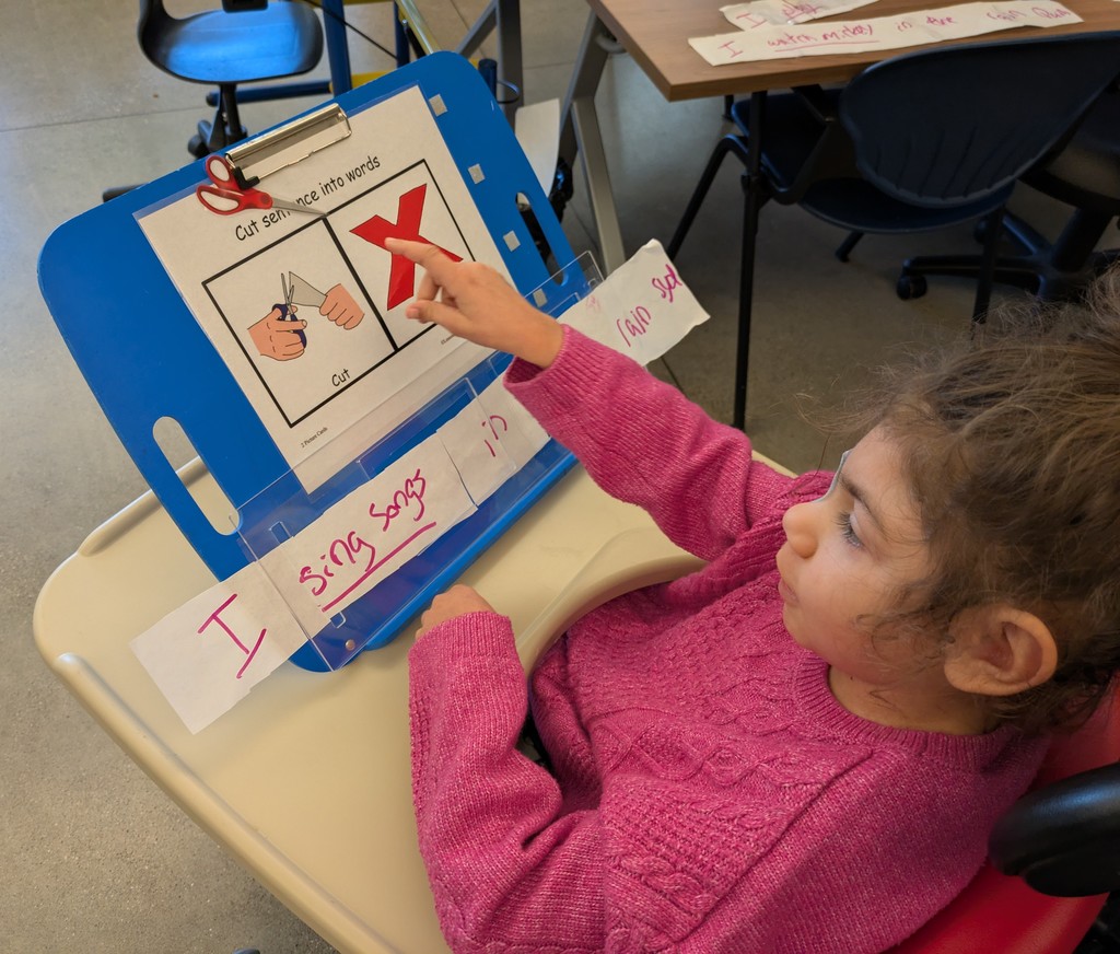 Student with a slant board on her desk.