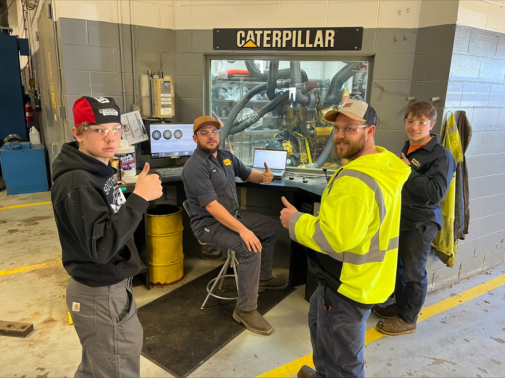 Kids and employers giving thumbs up at Caterpillar