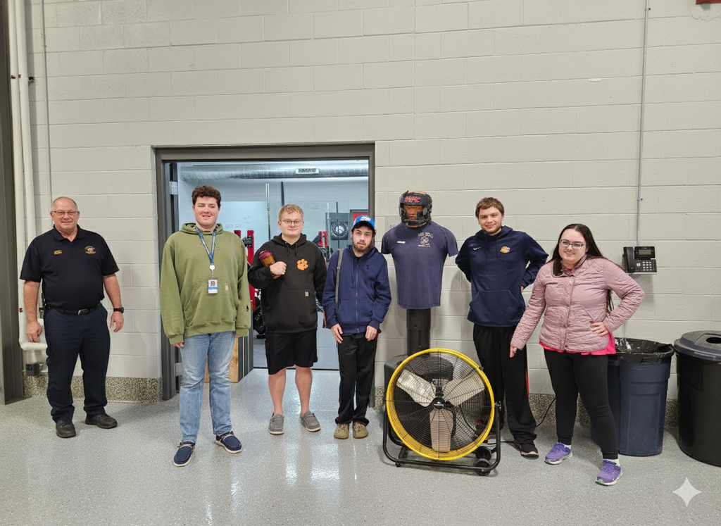A group of learners standing with a firefighter inside a fire department.