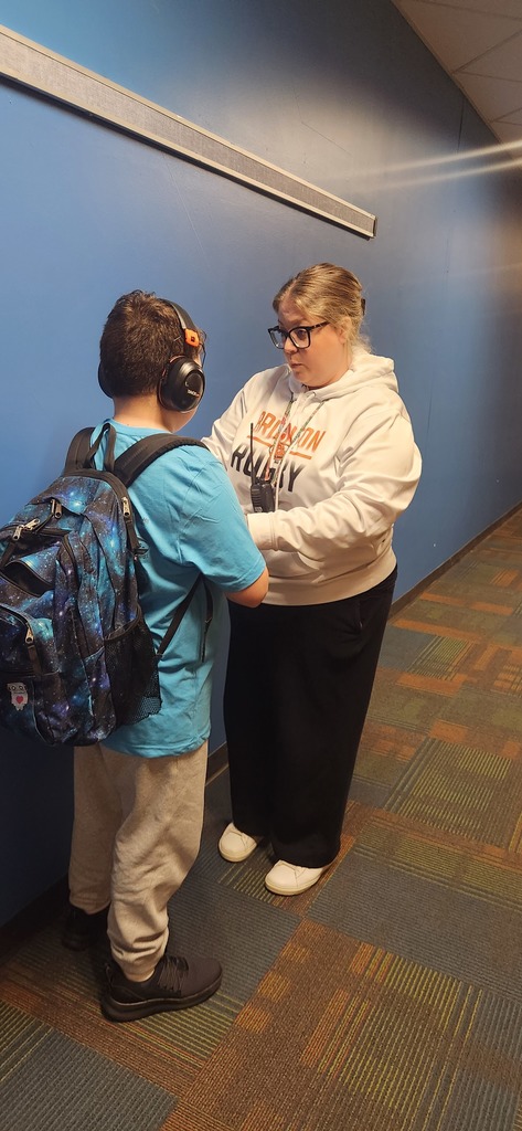 Brighton paraeducator Mrs. Madril sings to a student in the hallway to encourage self-regulation.