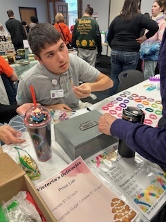 man sitting at craft show table