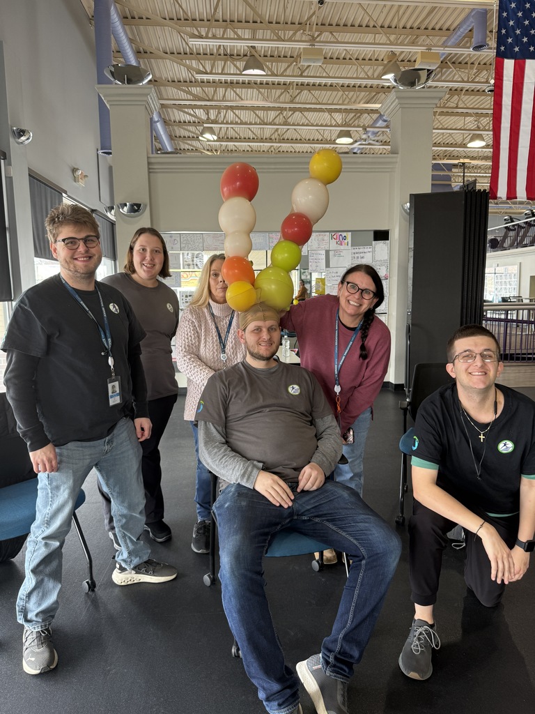Group of people with one person sitting with balloon antlers