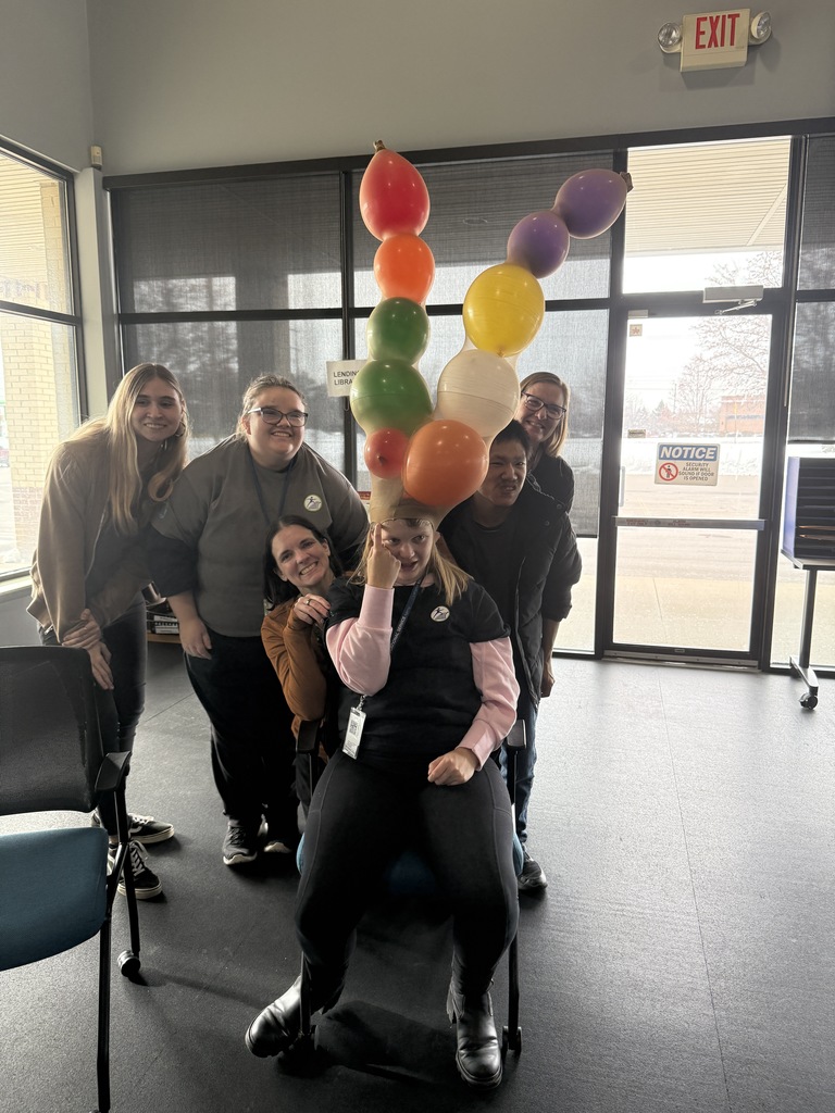 Group of people with one person sitting with balloon antlers