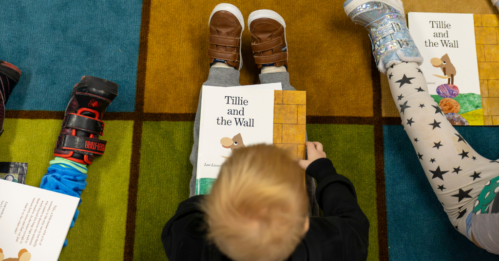 Young boy reading his new book.