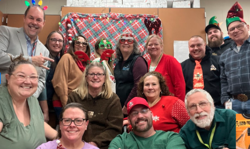 Poeple in a group photo dressed up in Christmas accessories