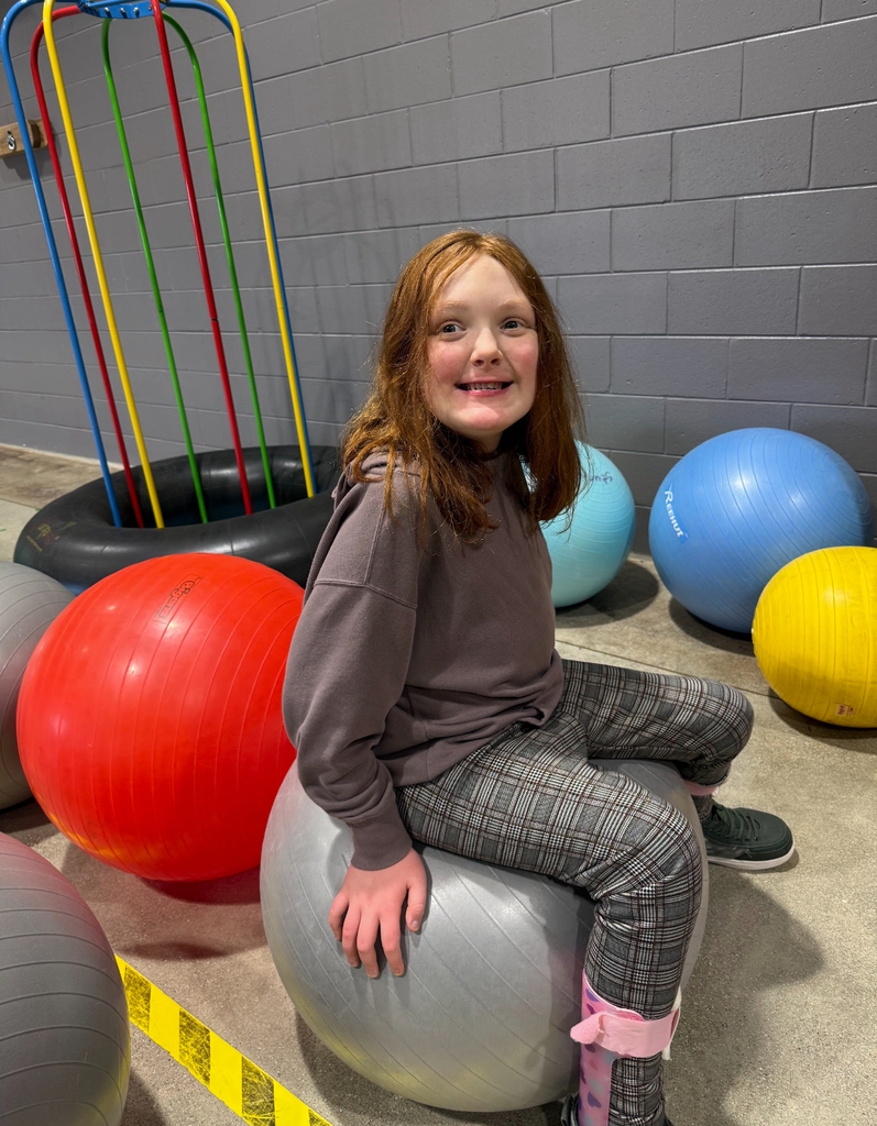 A student sits on a therapy ball during gym