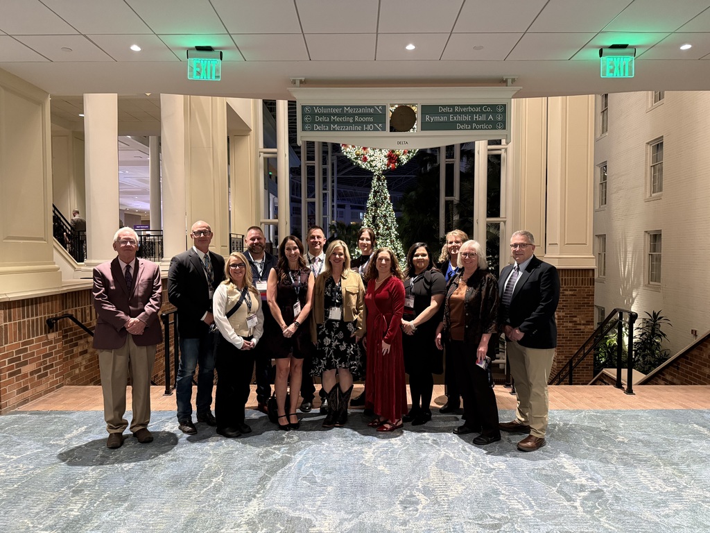 A group of people posing in front of a staircase.
