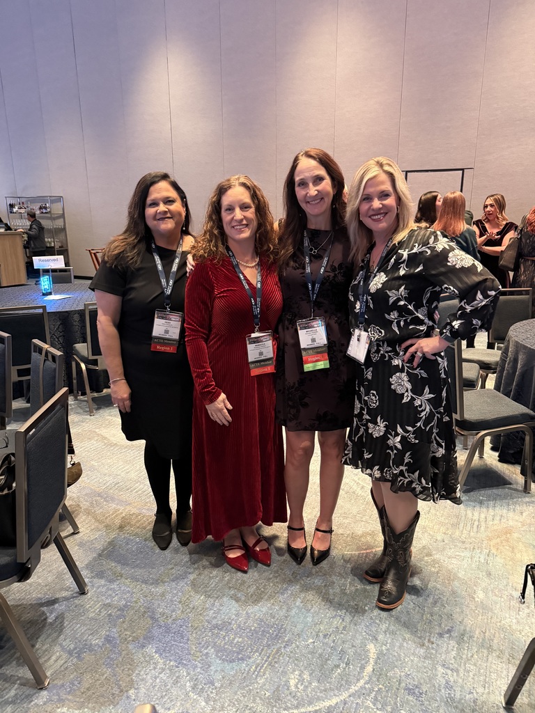 Four woman posing together smiling.