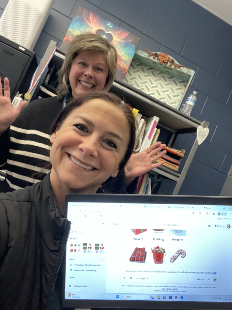 Two staff in front of a computer screen smiling