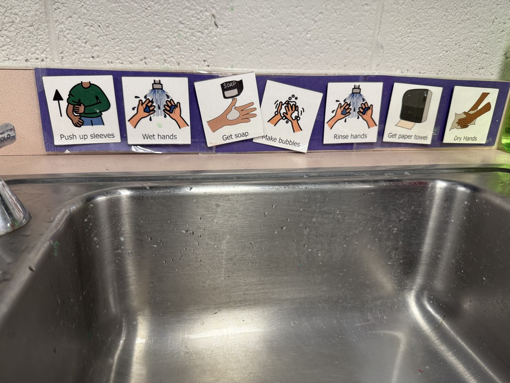 Visual handwashing routine posted above a classroom sink showing each step with pictures and words.