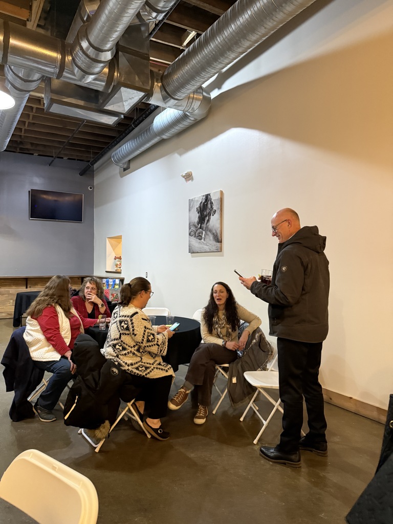 Group of people sitting. One person is standing