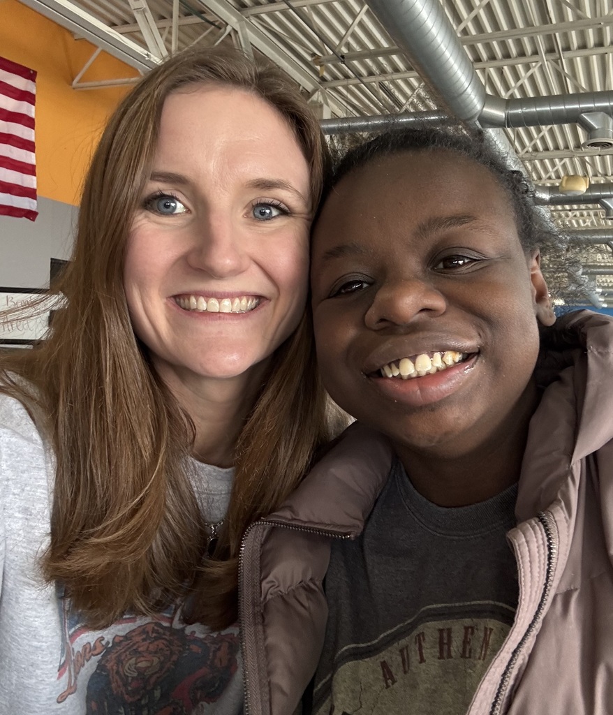  A female teacher and young adult student smiling.
