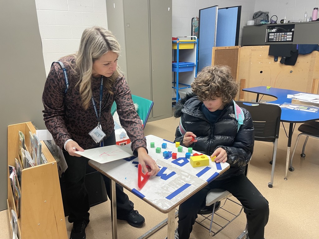 Adult showing student the letter A.