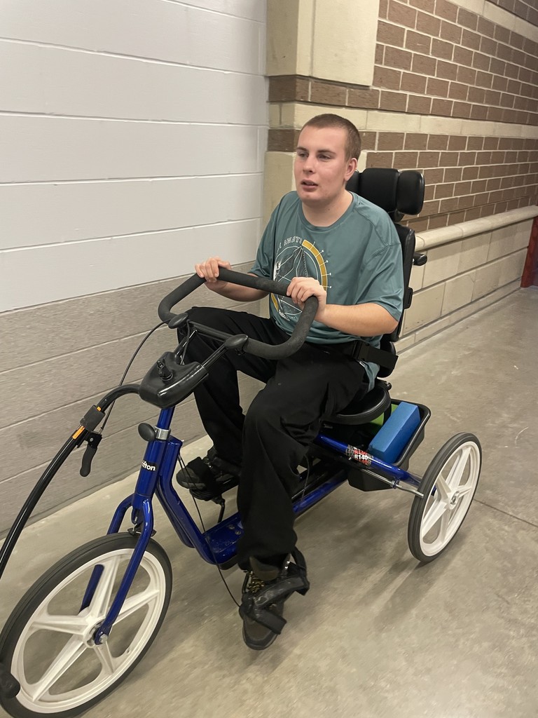 Young adult riding a bike in the hall.
