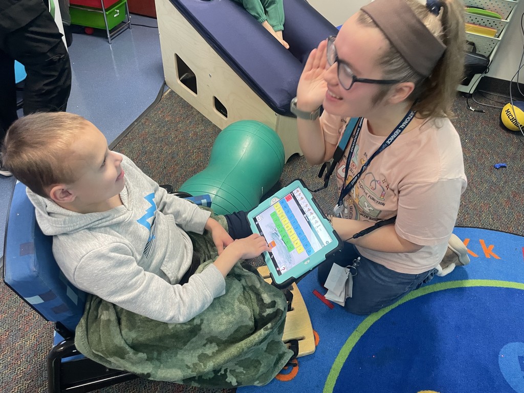 Teacher showing a student the keyboard on an iPad.