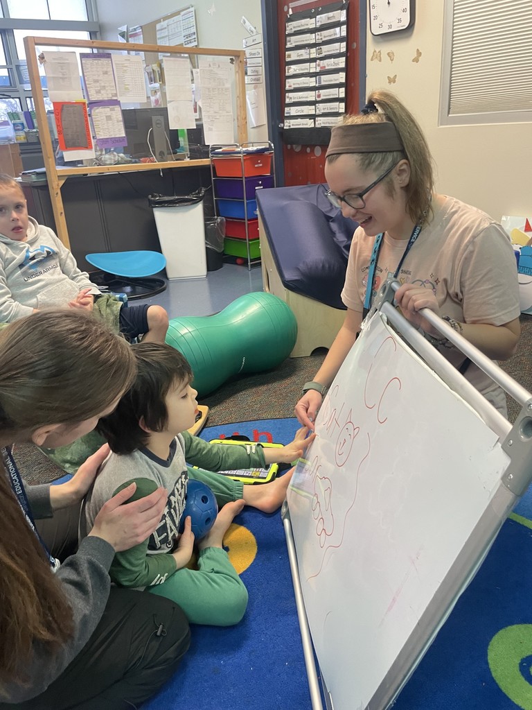 Teacher showing a student the dry erase board.