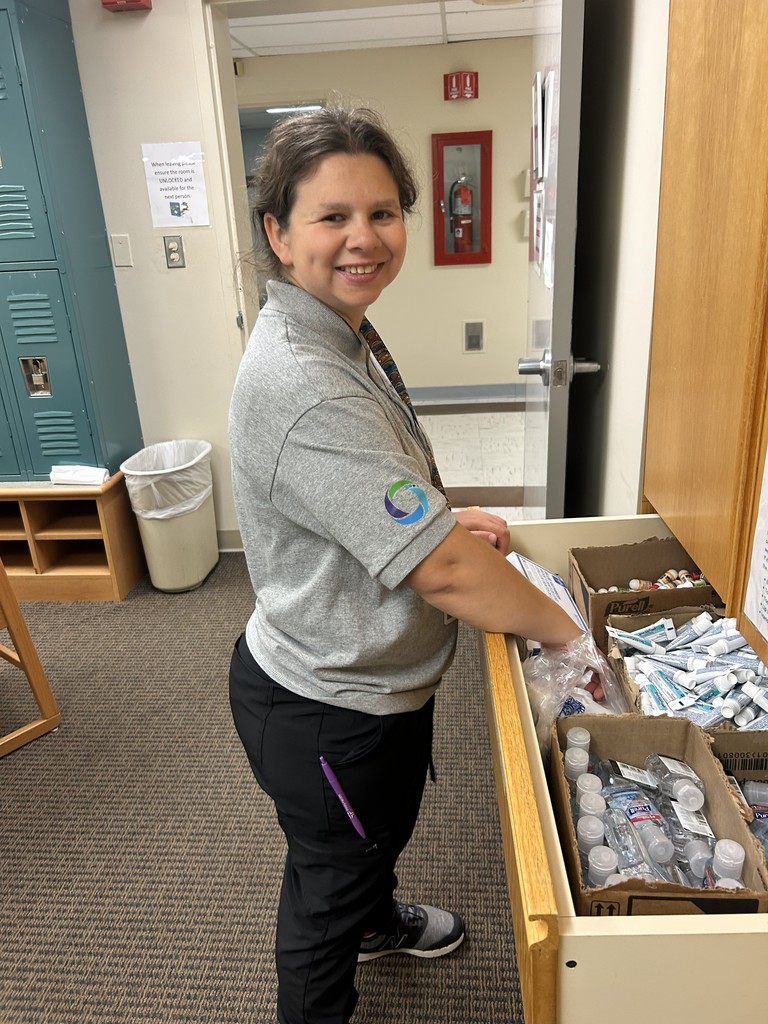 Woman with drawer open. Draw contains lots of bottles and products in hospital setting