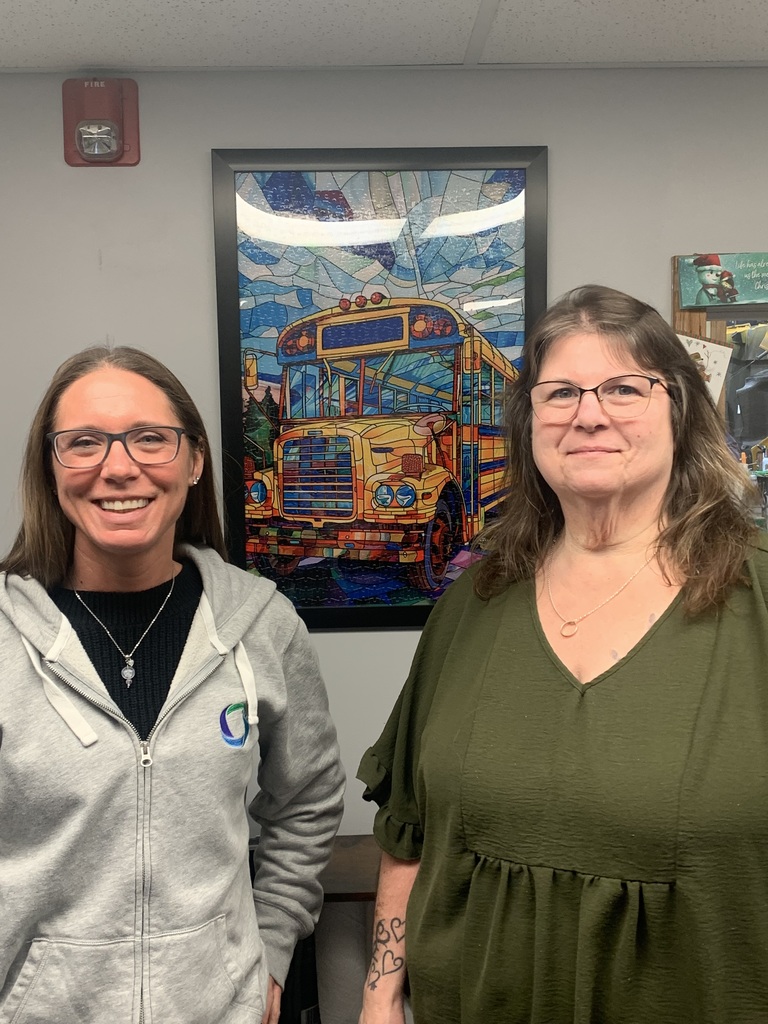 2 ladies standing in front of a school bus photo
