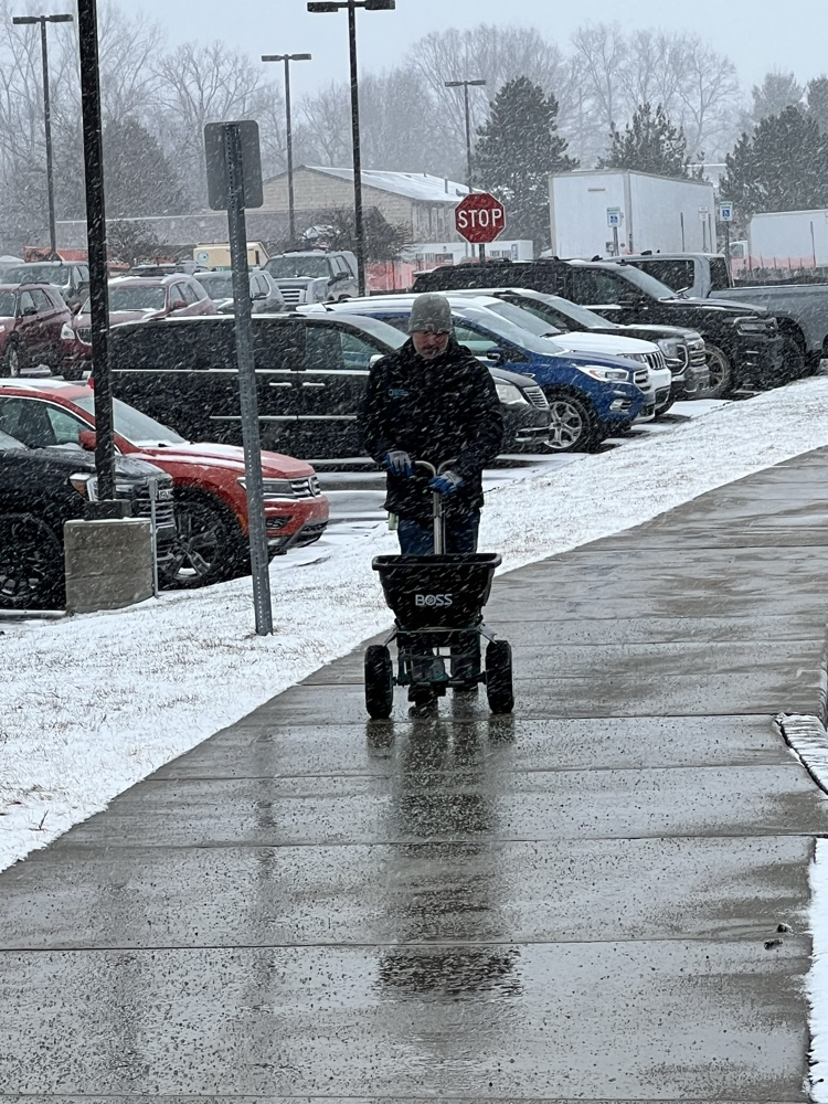man salting sidewalks 