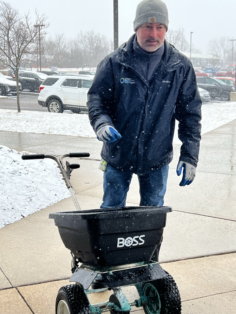 man salting sidewalks 