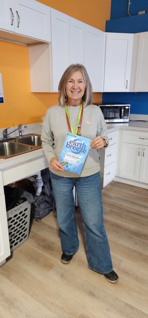 A female adult standing in front of a kitchen sink.