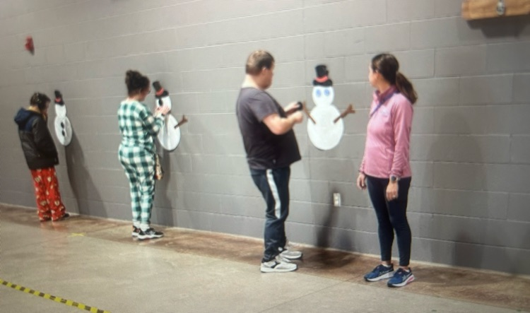 several students standing next to a snowman 