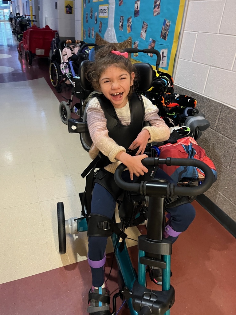 Little girl with a huge smile on an Rifton adaptive tricycle