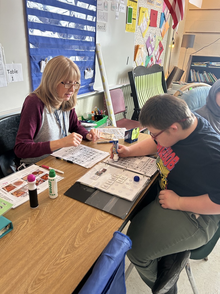 Student sitting at table working with teacher