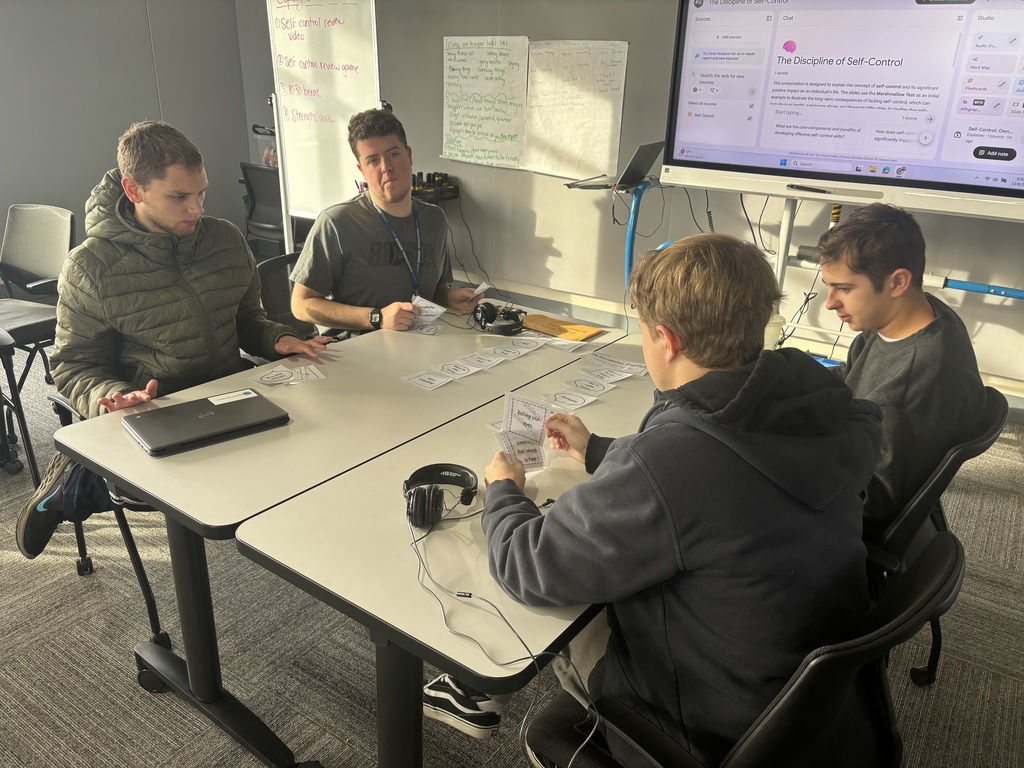Four young men sitting around a table.
