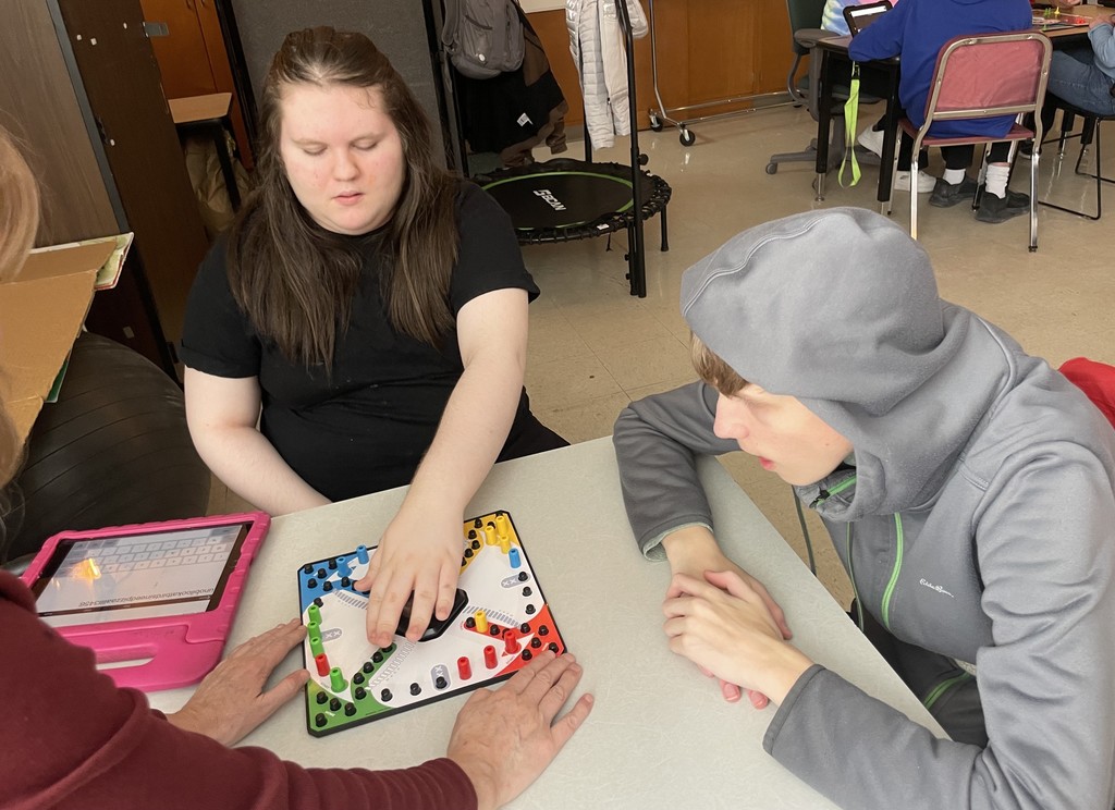 Two students playing the game Trouble.