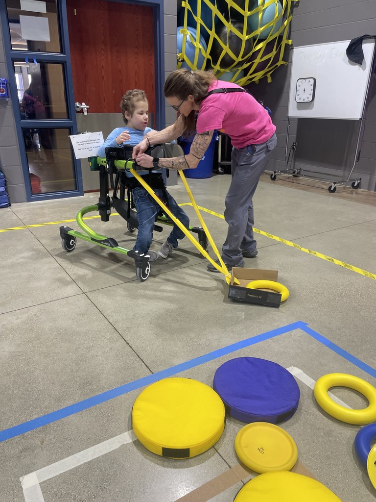 Staff member attaching an adapted curling stick to a gait trainer.