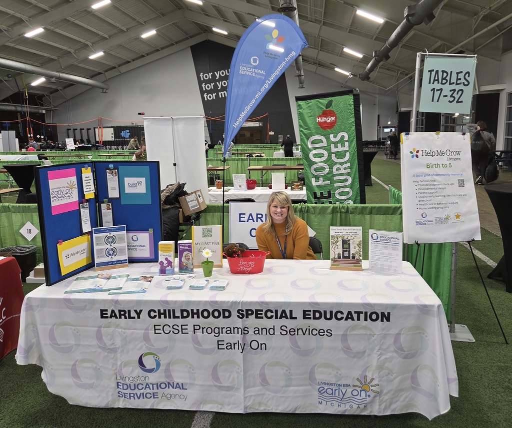 Woman sitting at table handing out information.