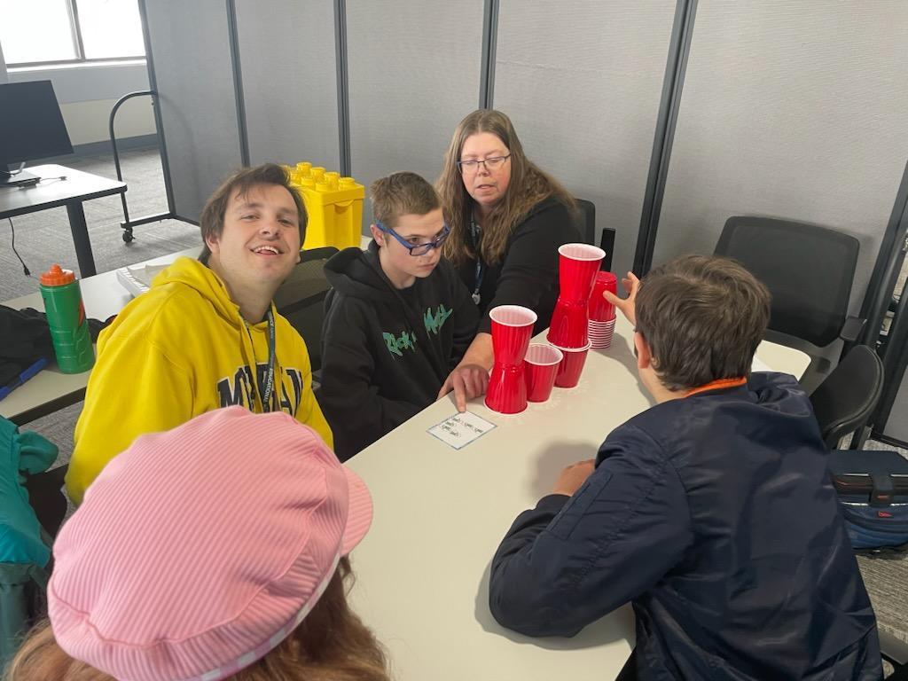 Group sitting around a table staking cups
