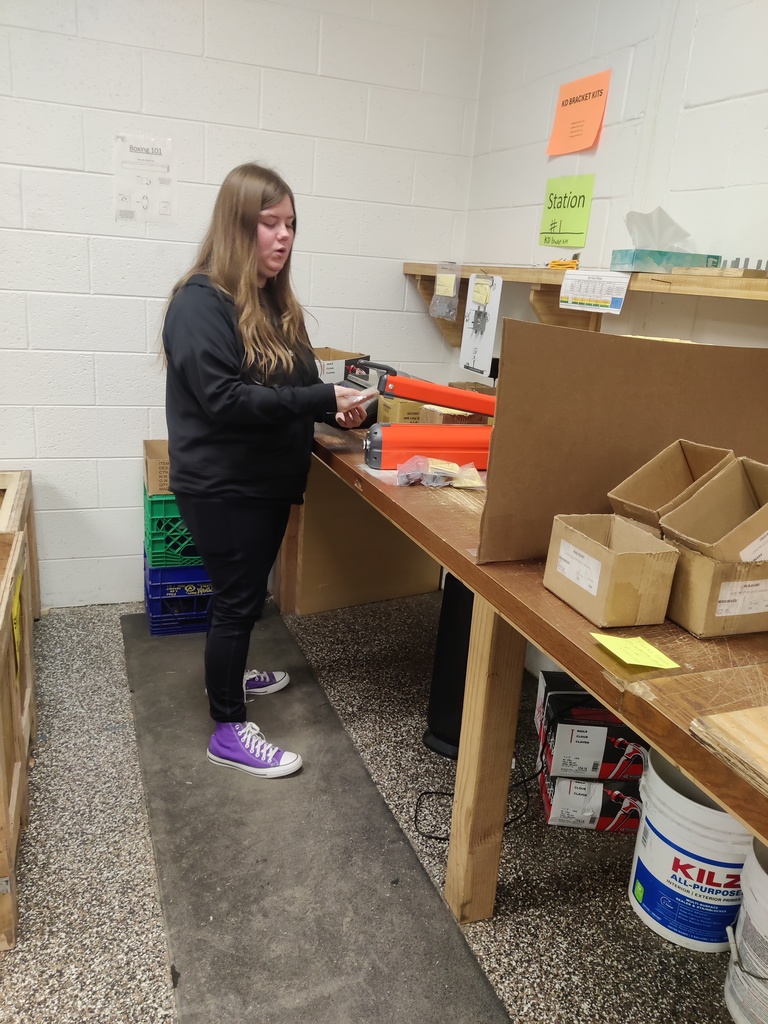 Person working in a factory setting assembling parts