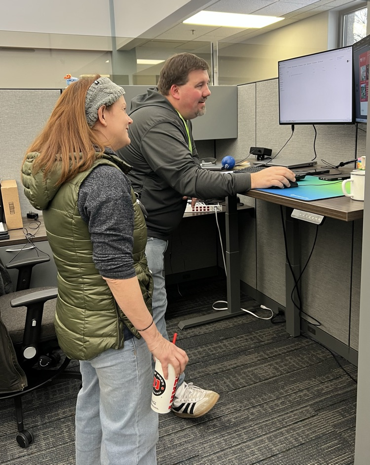 Male and Female standing at a computer 