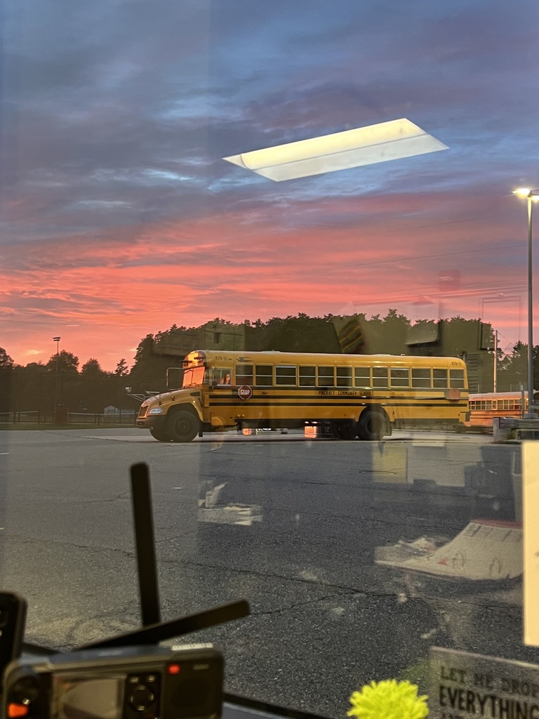 Photo of the sunrise with a school bus in front of it