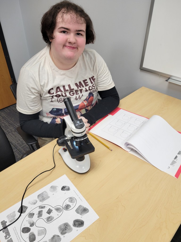 Student with microscope and fingerprints