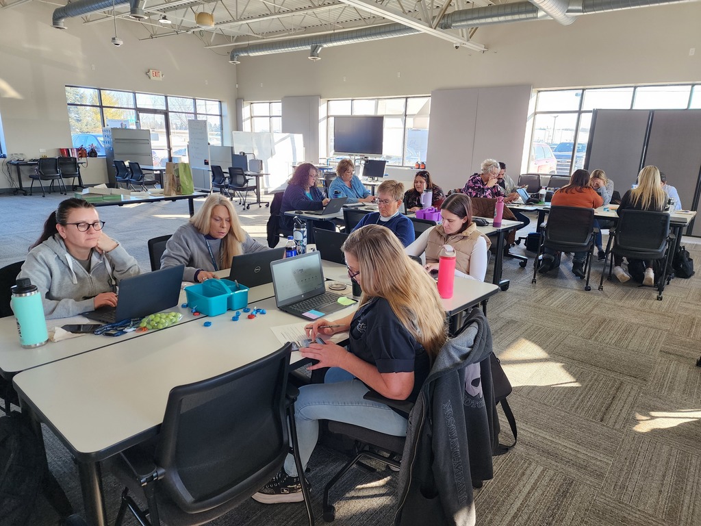 People sitting at desks working in a classroom setting.