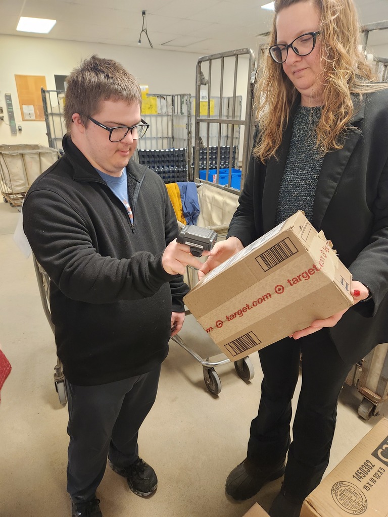 Young adult scanning a package at the post office.