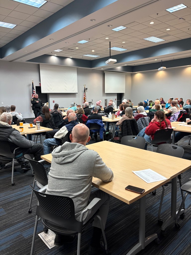 Photo of a staff meeting and an officer speaking
