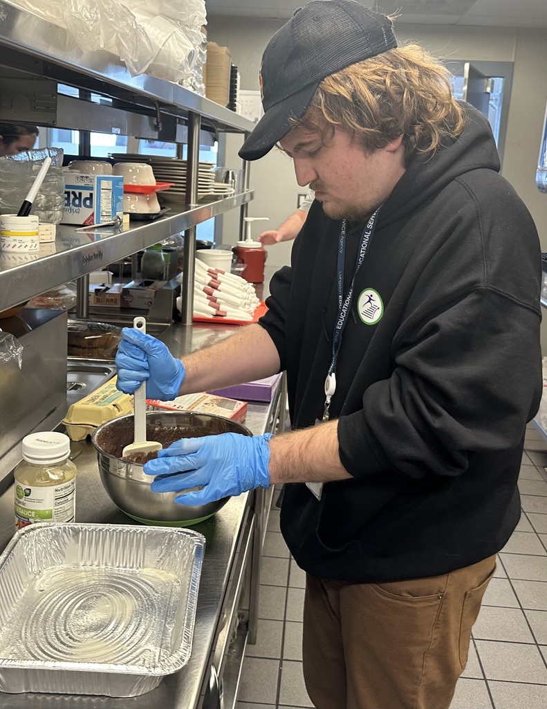 Person stirring food in a bowl in a commercial kitchen