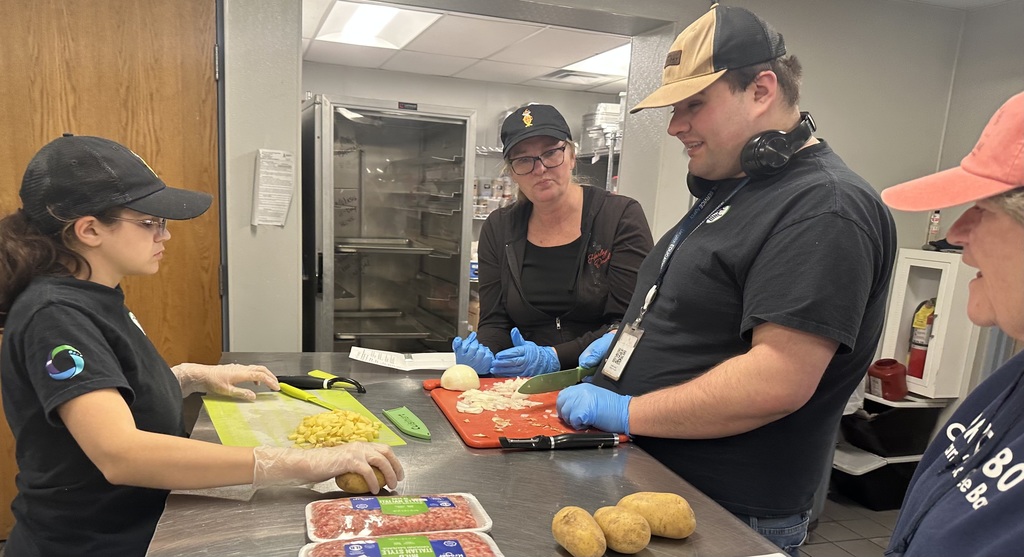 People standing around a table preparing food