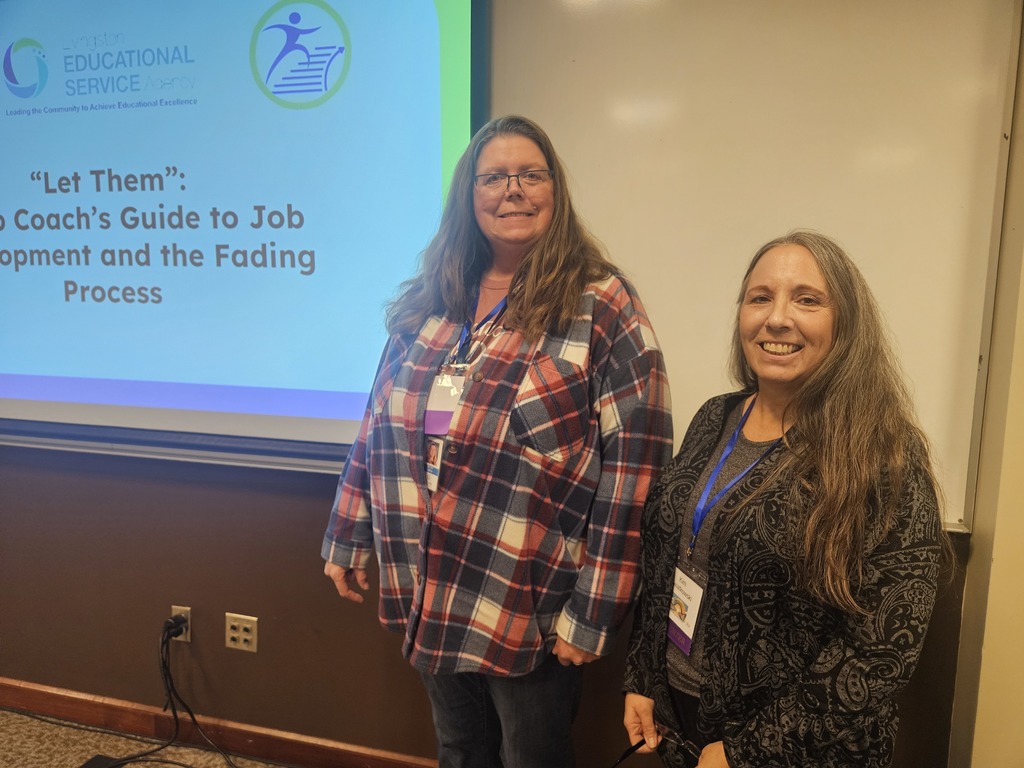 Two ladies standing near a screen that says "Let Them: A Job Coach's Guide to Job Development and the Fading Process