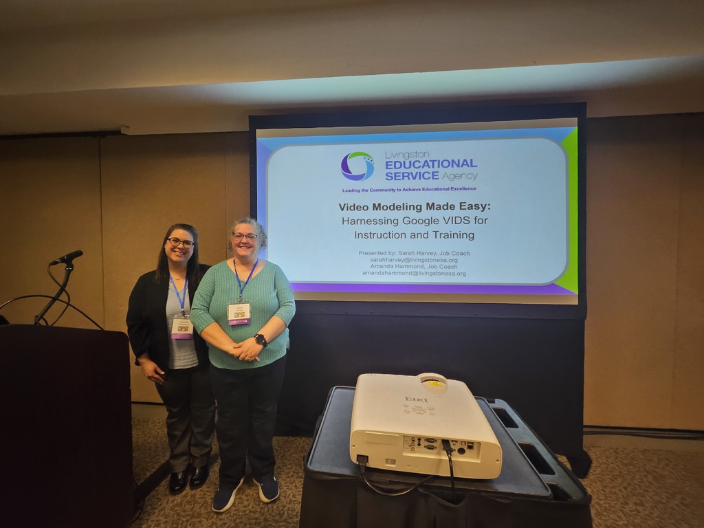Two ladies standing near a screen that reads video modeling made easy