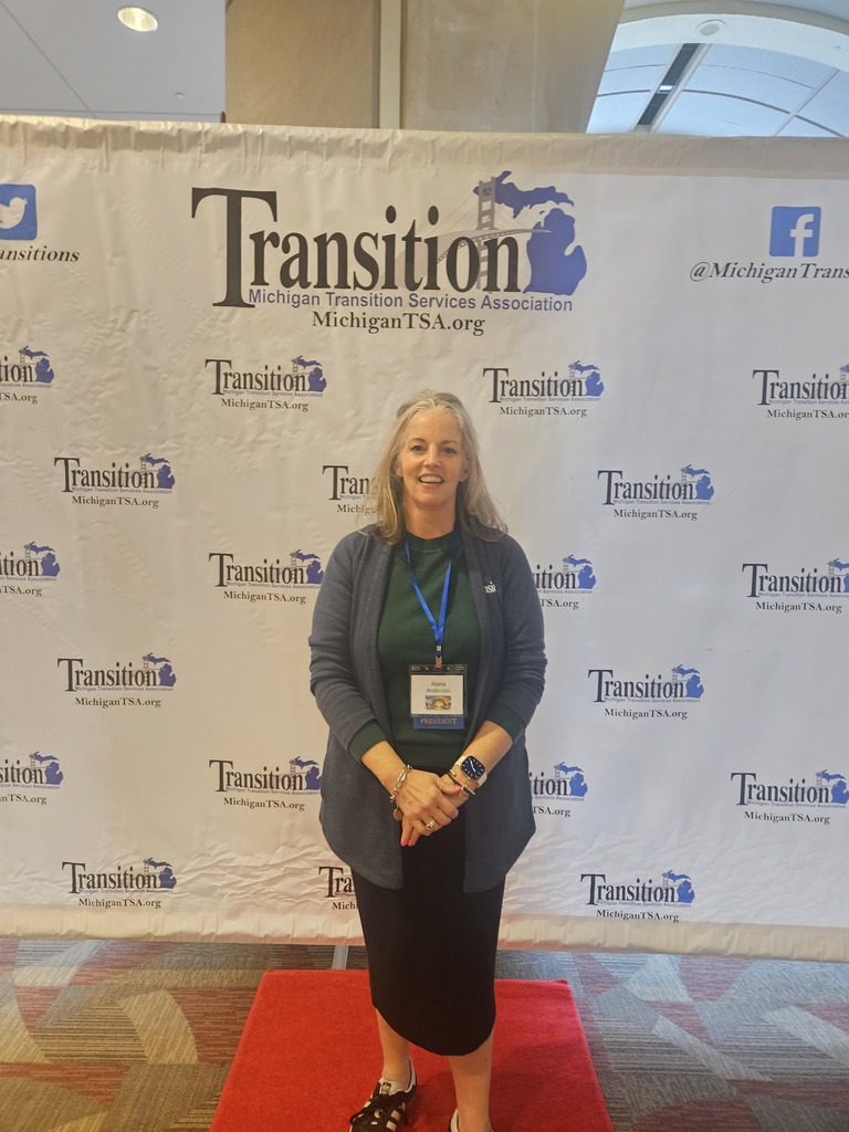 Woman standing in front of the Michigan Transition Services Association backdrop
