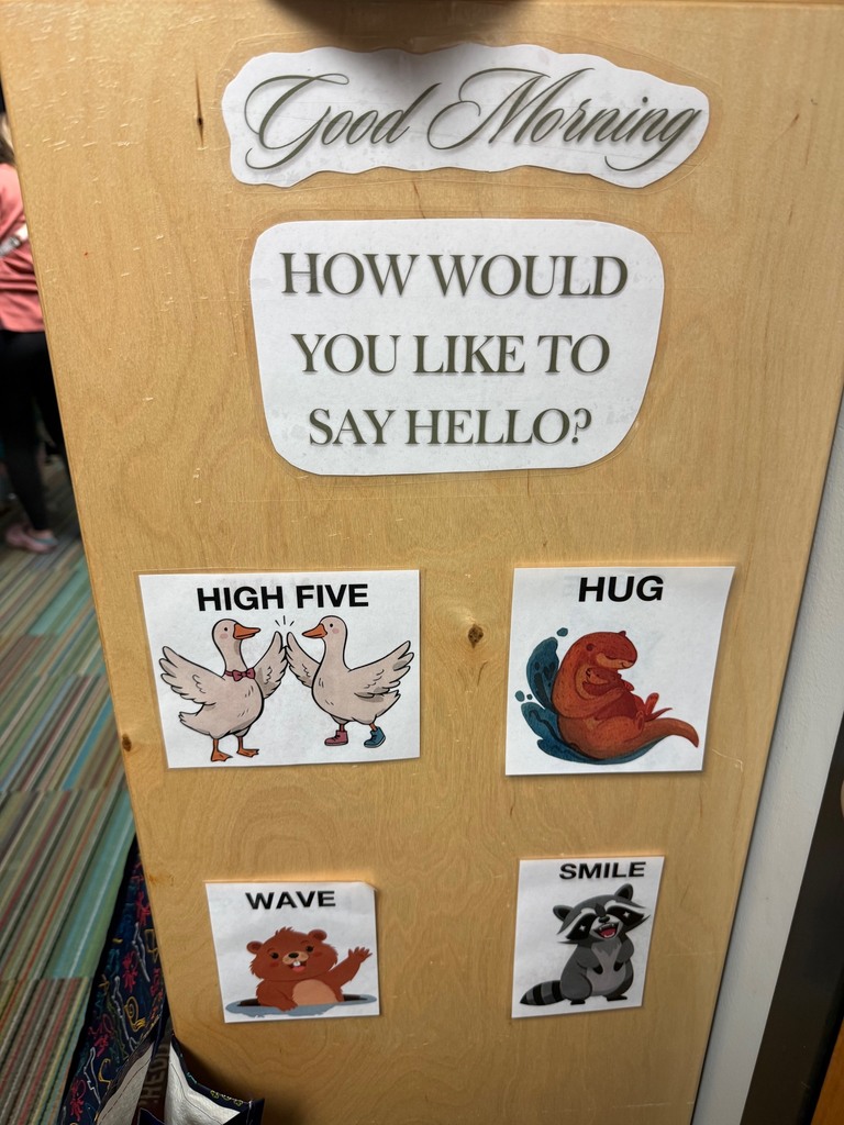 A wooden classroom greeting chart that reads “Good Morning. How would you like to say hello?” with picture options labeled high five, hug, wave, and smile.