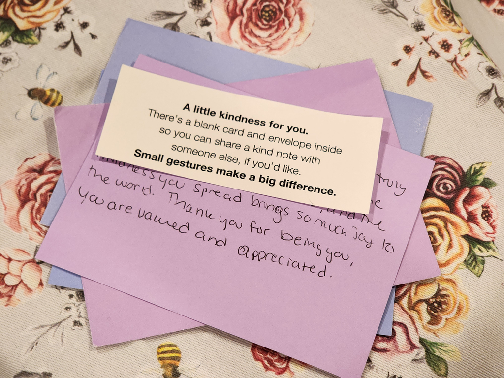 Envelope and hand written letter laying on top of a floral background.