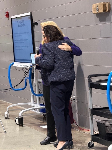 Two women with arms around each other.