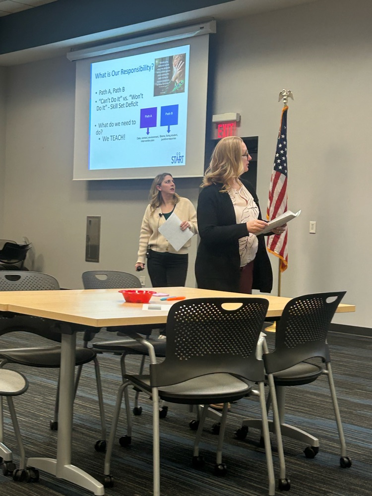 two staff standing in front of room